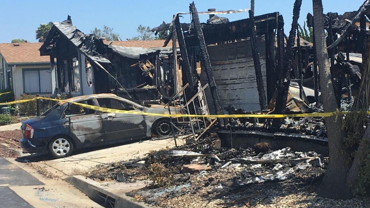 A burned car sits in the driveway of a mobile home that exploded in Santa Maria.