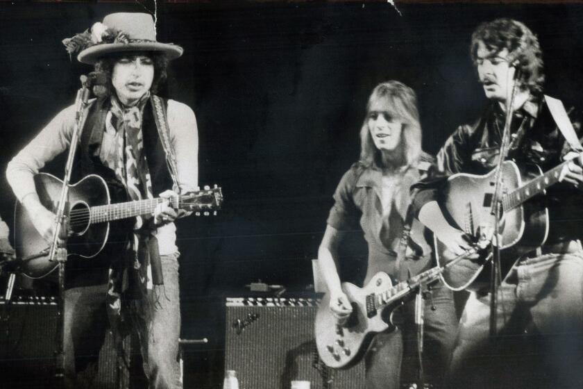 TORONTO, ON - DECEMBER 2, 1975: His rolling thunder revue making its way toward New York, Bob Dylan (left) last night took centre stage before 16,000 people at Gardens, accompanied by a host of other folk music personalities including Mick Ronson (centre) and Bobby Neuwirth. Joni Mitchell was there, and Ramblin' Jack Elliott and Ronee Blakley and Roger McQuinn and Gordon Lightfoot. Joan Baez joined in duet with Dylan, her dignity filling hall, according to Star writer Peter Goddard. (Frank Lennon/Toronto Star via Getty Images) ** OUTS - ELSENT, FPG, CM - OUTS * NM, PH, VA if sourced by CT, LA or MoD **