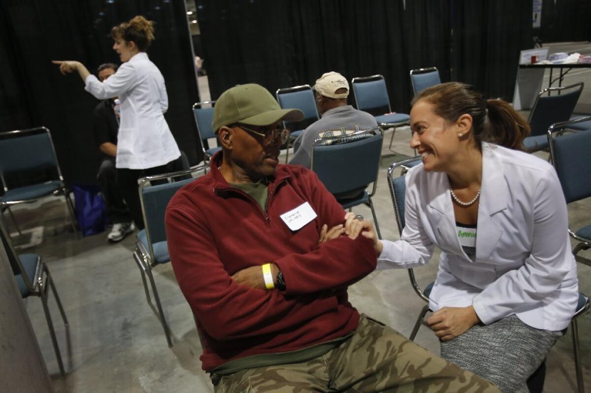 US Vets, a national nonprofit, has organized a "Stand Down" at the L.A. Convention Center to provide medical, financial and living assistance to homeless veterans. Annie Gigliotti, a nurse, talks with Clarence, a Vietnam veteran.