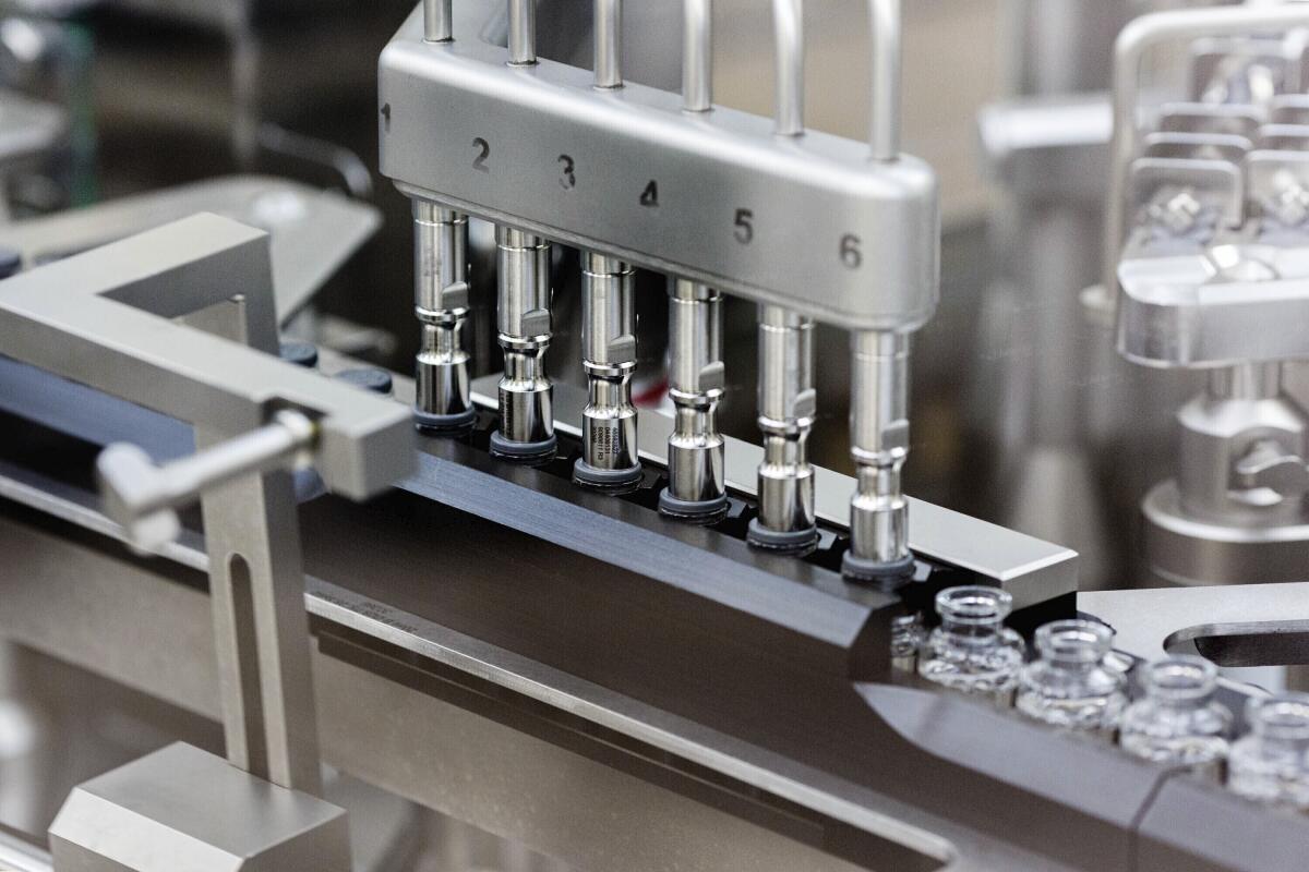 Rubber stoppers are placed onto filled vials of the investigational drug remdesivir at a Gilead manufacturing site in the United States. 