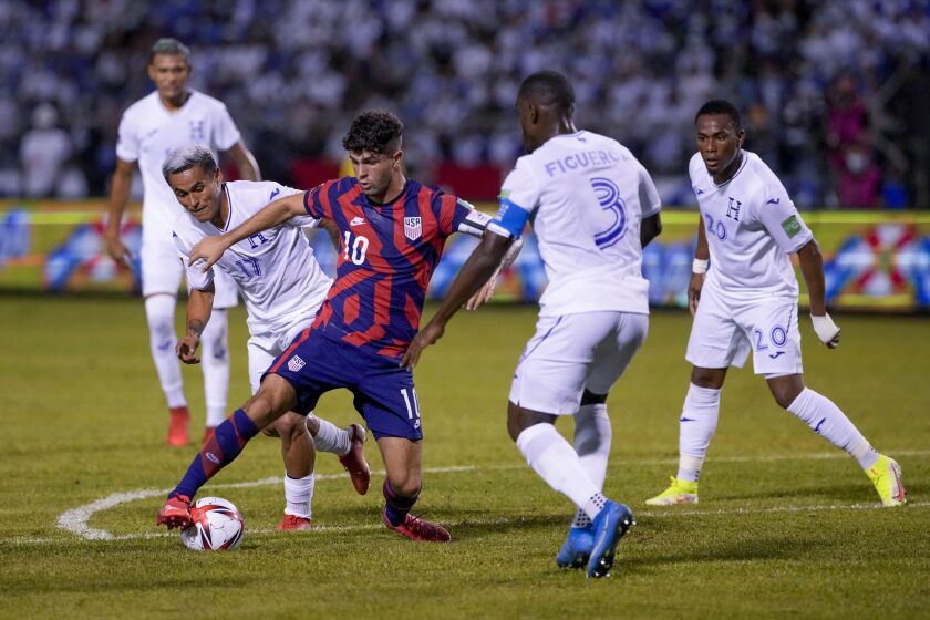 The United States' Christian Pulisic (10) dribbles the ball surrounded by Honduras players