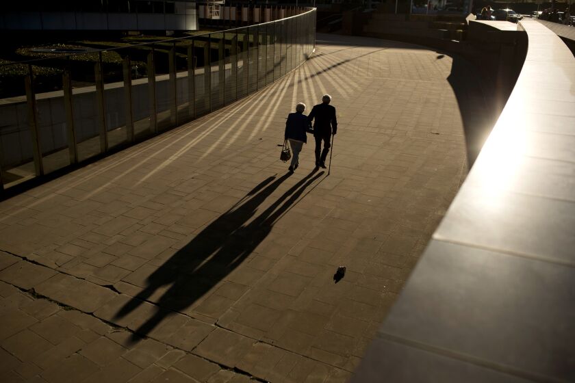 FILE - In this Thursday, Sept. 27, 2018 file photo, an elderly couple walks past the Berlaymont building, the European Commission headquarters, in Brussels. Research released on Sunday, July 14, 2019 suggests that a healthy lifestyle can cut the risk of developing Alzheimer's even if you've inherited genes that raise your risk for the mind-destroying disease. (AP Photo/Francisco Seco, File)