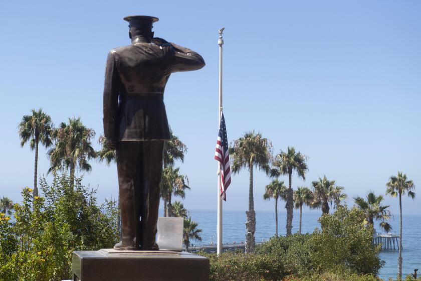 The U.S. flag was lowered to half-staff at Park Semper Fi in San Clemente, Calif., on Friday, July 31, 2020. Officials say a military seafaring assault vehicle with 15 Marines and a Navy sailor aboard sank off the coast of Southern California, leaving one of the Marines dead and eight missing. A Marine Corps spokesman says they were traveling in the amphibious assault vehicle from the shores of San Clemente Island to a Navy ship Thursday evening when they reported that the vehicle was taking on water. (Paul Bersebach/The Orange County Register via AP)