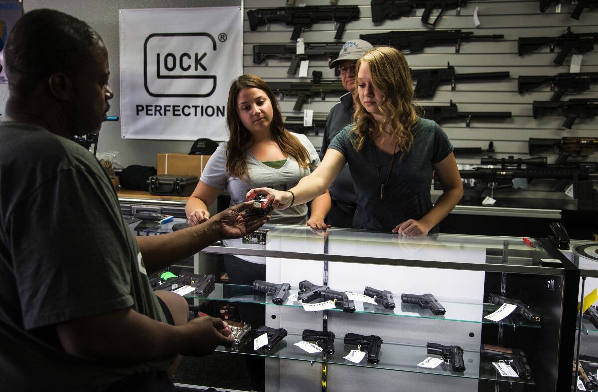 A customer at a gun store counter 