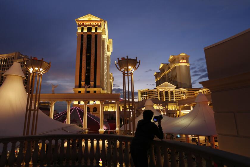 ARCHIVO - Un hombre toma imágenes del hotel y casino Caesars Palace en Las Vegas, el 12 de enero de 2015. (AP Foto/John Locher, Archivo)