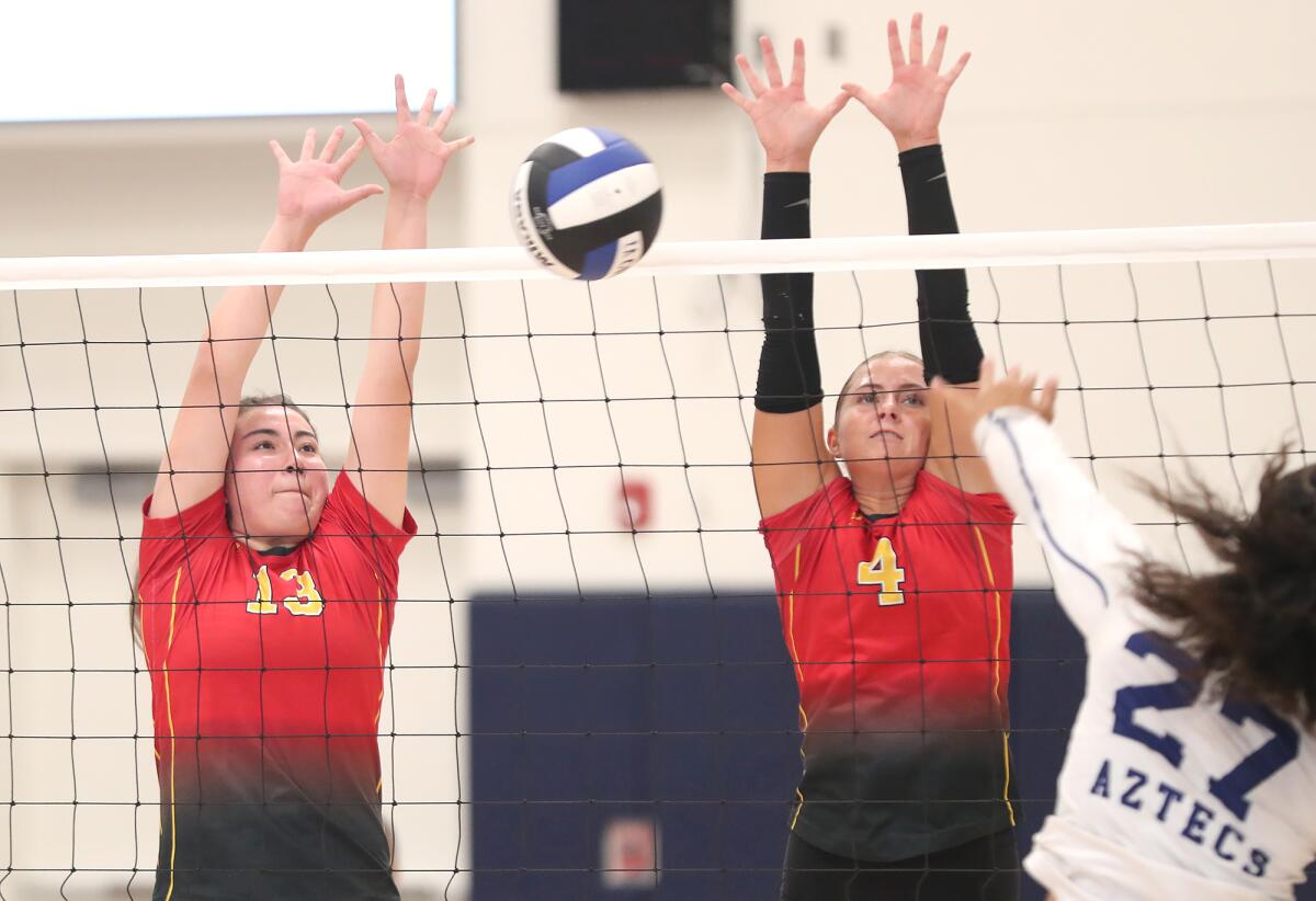 Estancia's Briget Anguiano (13) and Jenna Schroeder (4) block La Quinta's Raellie Faatuga (27) on Tuesday.