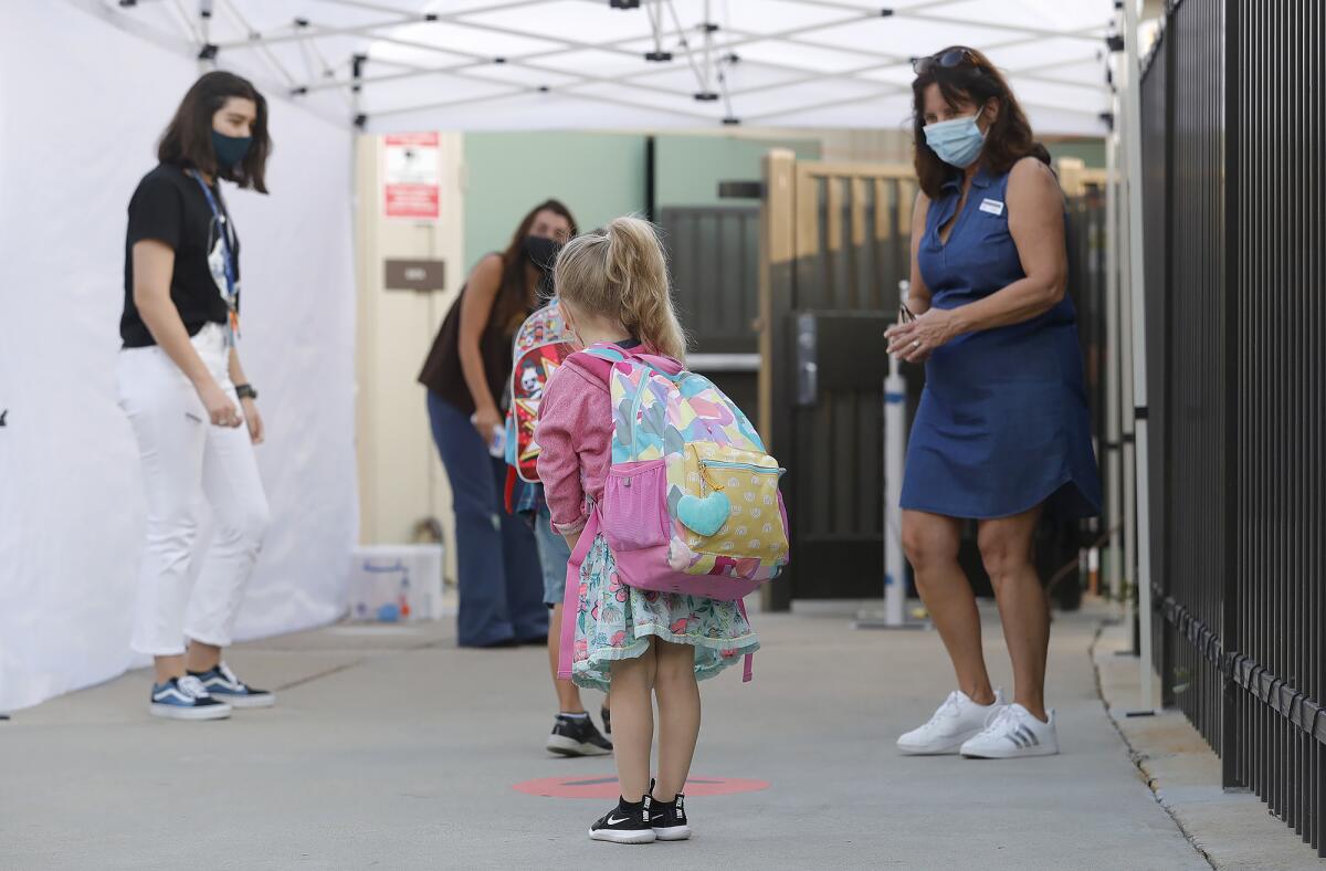 A kindergartner is greeted at a pre-screen station at Top of the World Elementary in October 2020. 