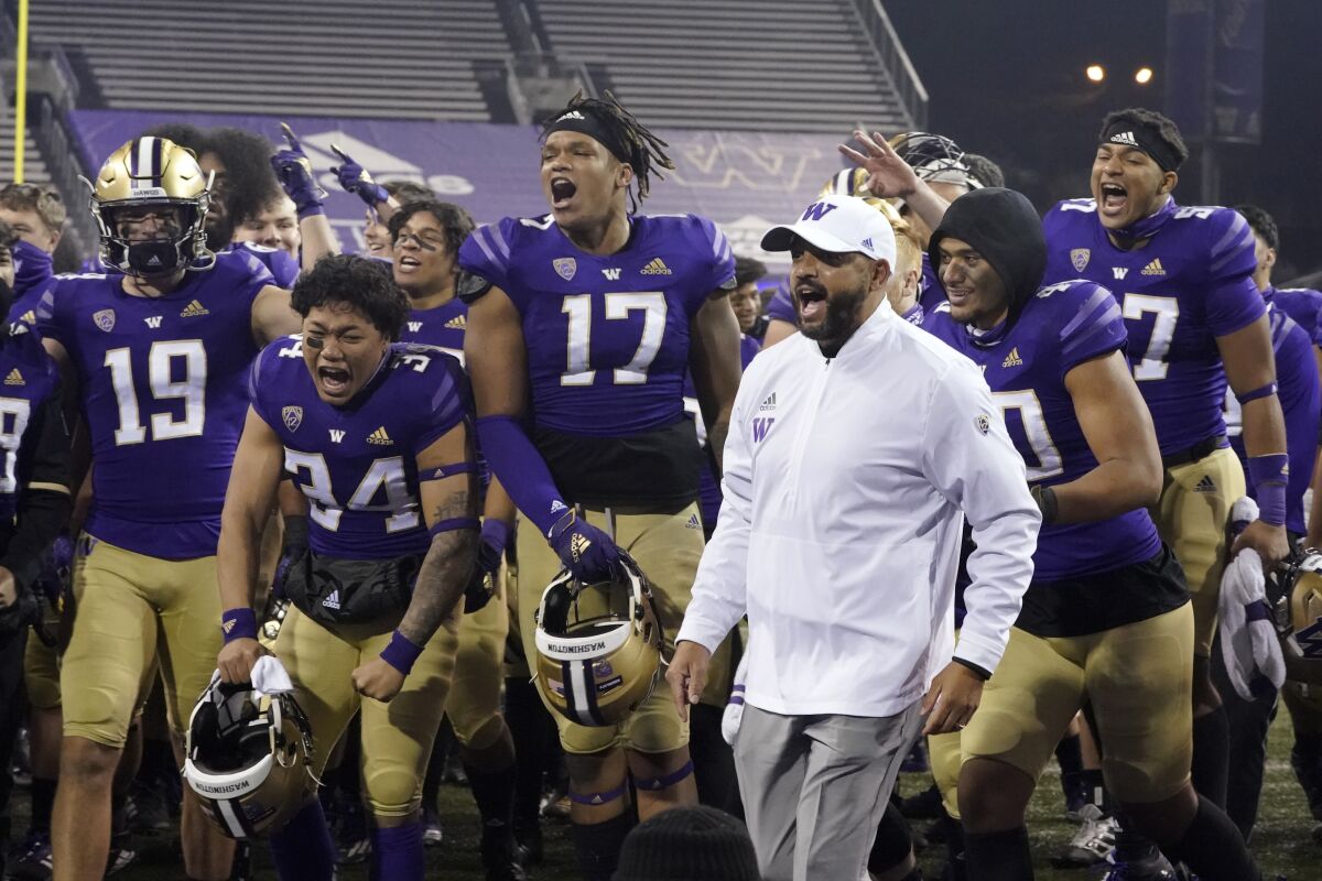 Washington coach Jimmy Lake celebrates with his players after a win over Utah.