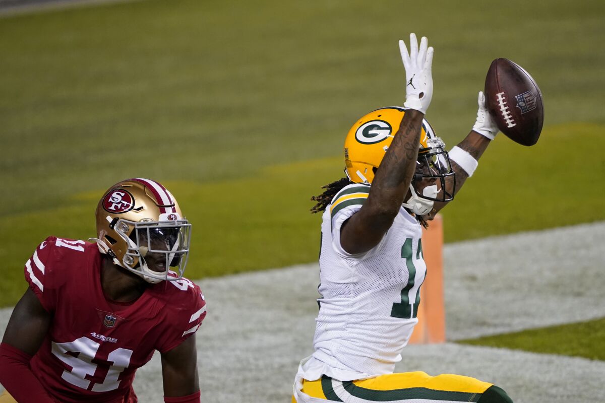 Green Bay Packers wide receiver Davante Adams, right, celebrates after catching a touchdown pass next to San Francisco 49ers cornerback Emmanuel Moseley (41) during the first half of an NFL football game in Santa Clara, Calif., Thursday, Nov. 5, 2020. (AP Photo/Tony Avelar)