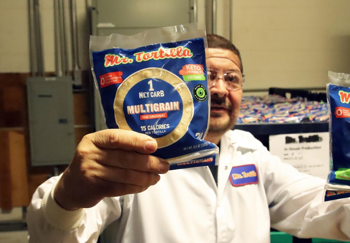 Tony Alcázar, de 64 años y fundador de Mr. Tortilla, muestra el producto emblema de su negocio.