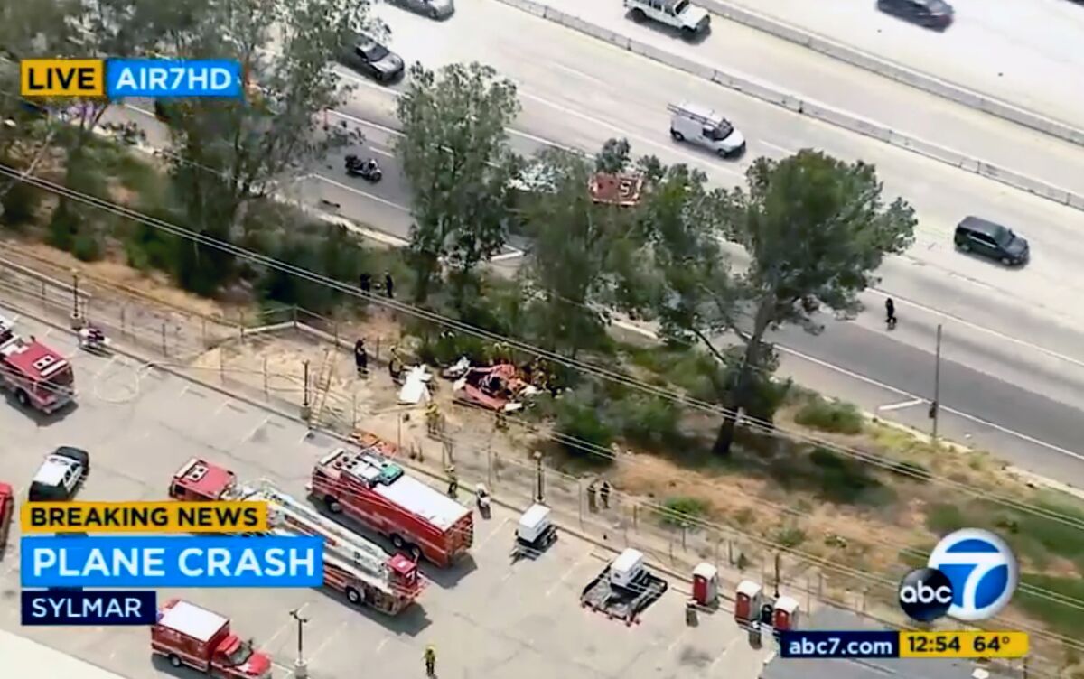 This aerial image taken from video provided by KABC-TV shows firefighters responding to a small plane that crashed in Sylmar, Calif., Wednesday, April 20, 2022. The plane has crashed alongside a Los Angeles freeway and authorities say one person has been confirmed dead. Fire Department spokeswoman Margaret Stewart says firefighters are searching to determine whether there was anyone else aboard the plane. The plane was reported down shortly after noon Wednesday. Wreckage came to rest among trees alongside Interstate 210 in the Sylmar area of the northern San Fernando Valley. (KABC-TV via AP)