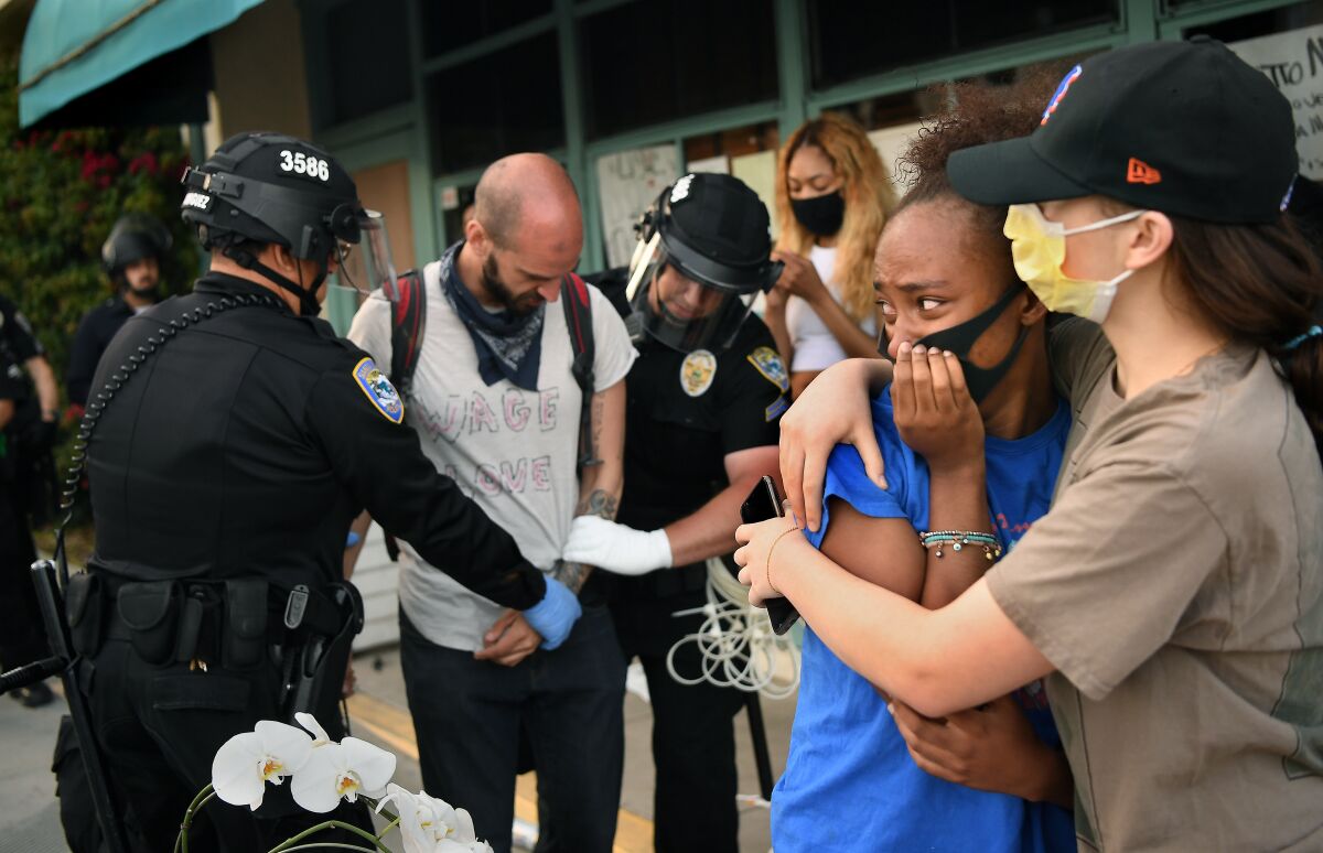 Protesters embrace as a man is arrested in Santa Monica on Sunday