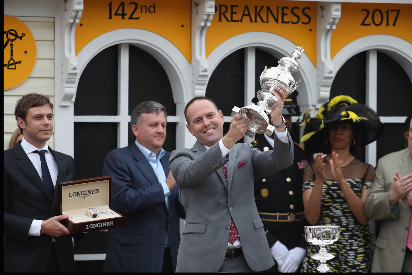 Cloud Computing trainer Chad Brown hoists the winner's trophy after the 142nd running of the Preakness Stakes.