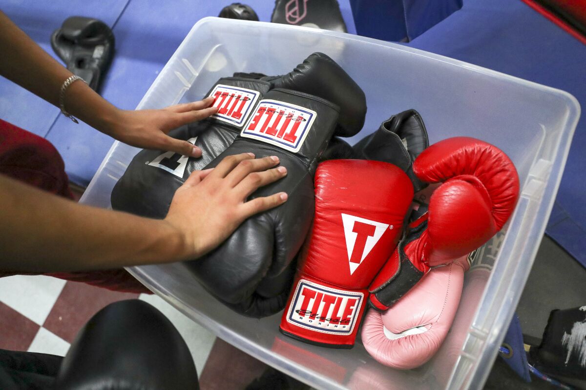 Imperial Boxing Youth Athletics Club members stuff boxing gloves into a box at the end of their workout on Thursday, December 19, 2019.