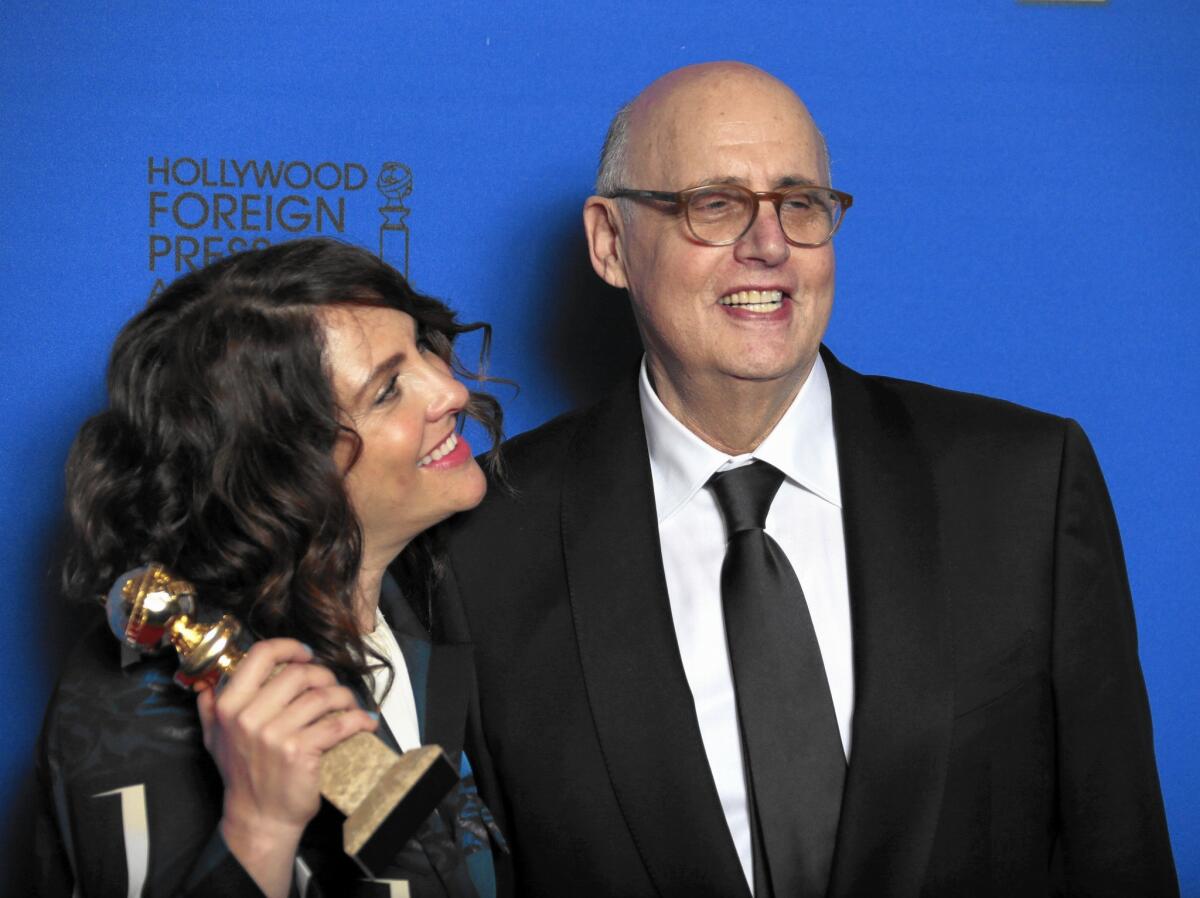 Jill Soloway holds "Transparent's" Golden Globe for comedy or musical television series beside the Amazon show's star, Jeffrey Tambor, who also won an award.