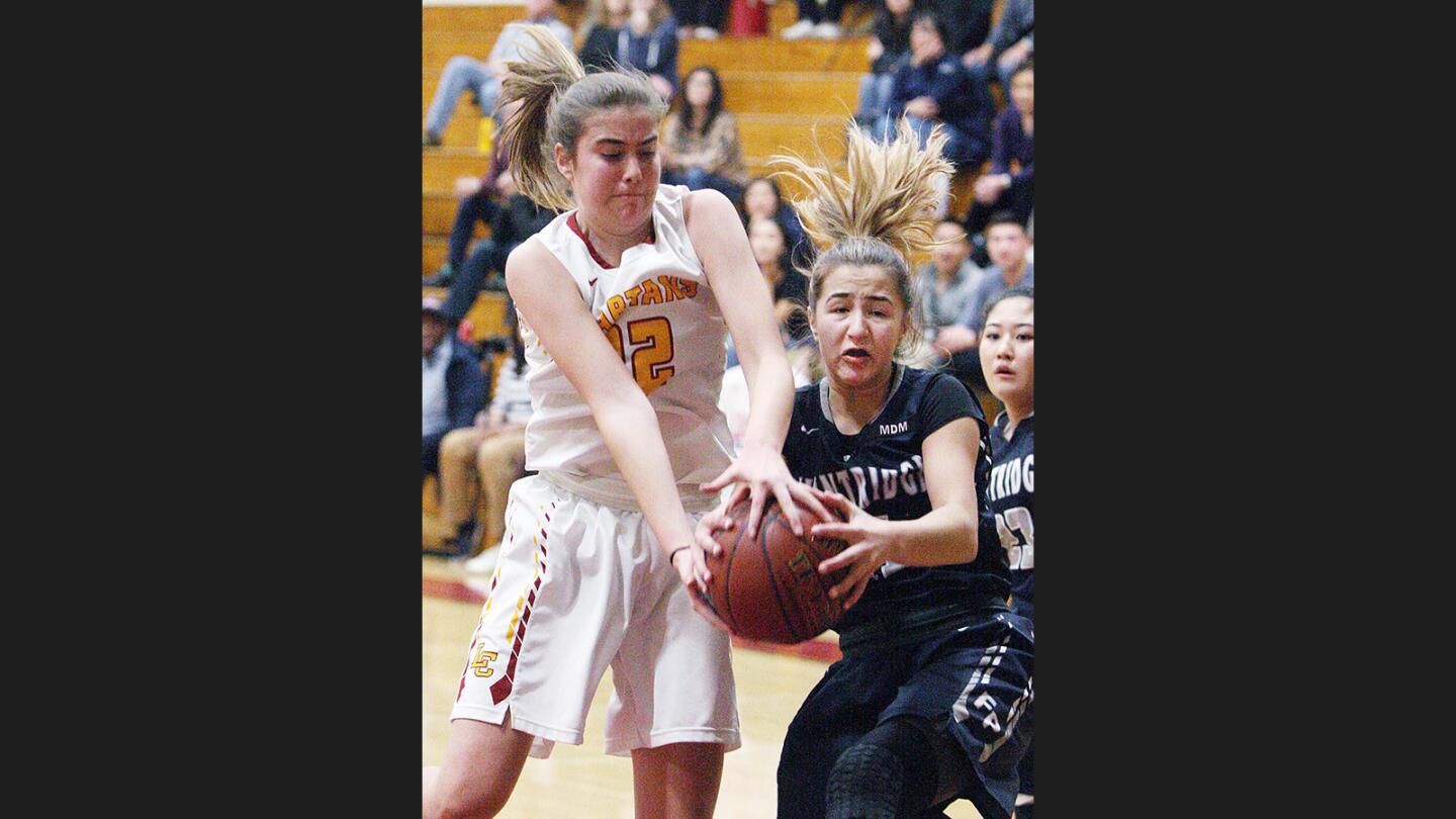 La Canada's Lauren Scoville and Flintridge Prep's Sofia Gonzalez battle for a loose ball in a girls' basketball tournament at La Canada High School on Wednesday, December 27, 2017.