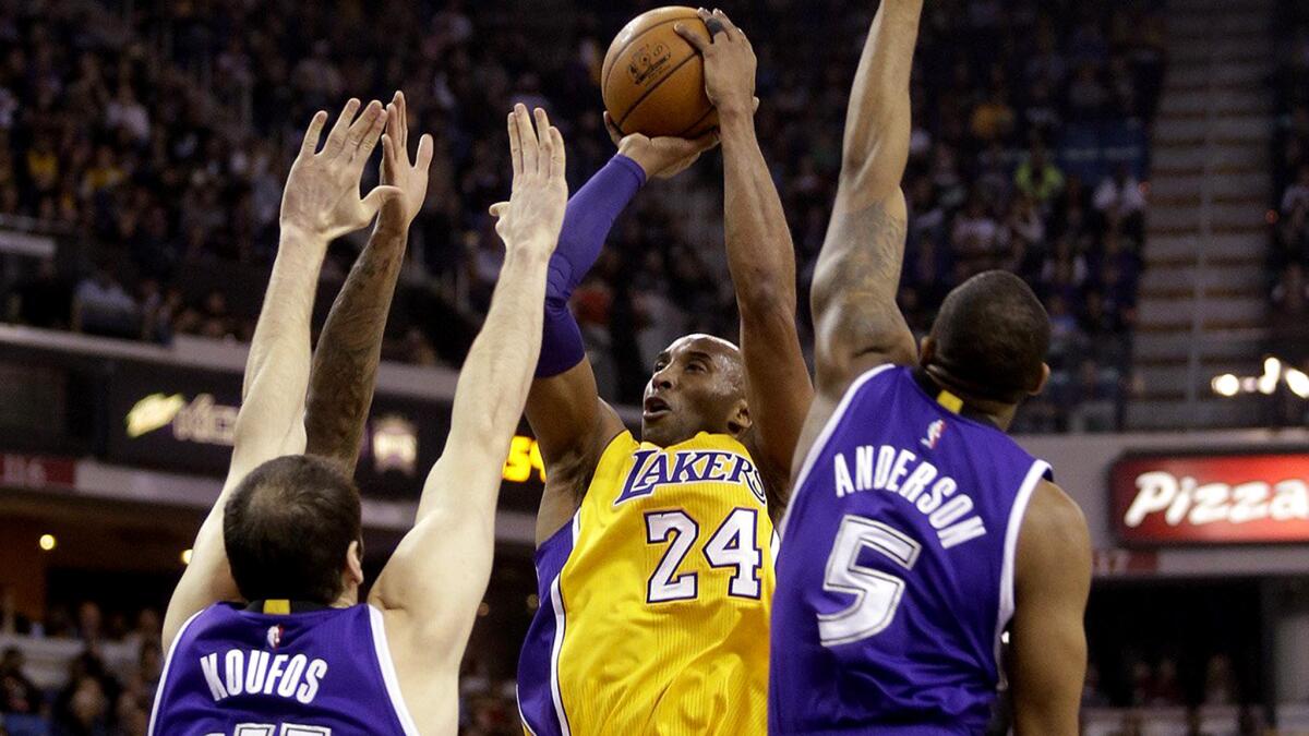 Lakers guard Kobe Bryant (24) shoots over a trio of Kings during the first half Thursday night in Sacramento.