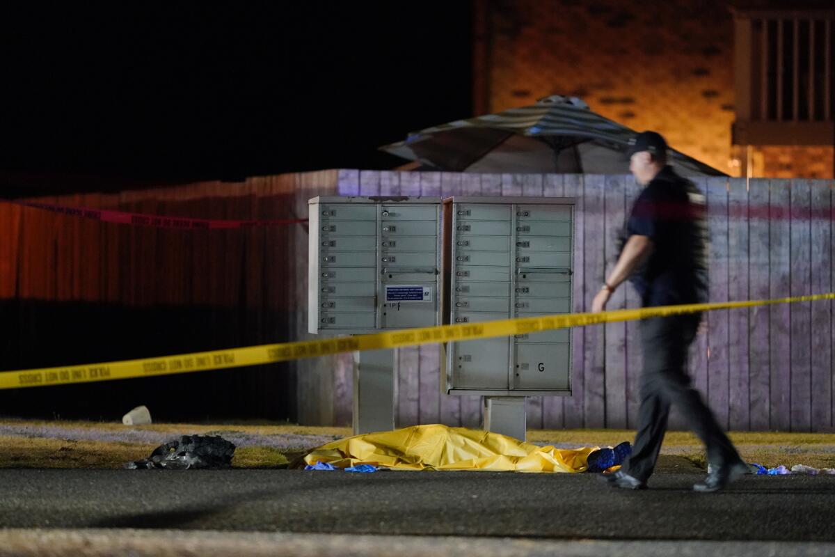 A tarp covers a body in Lacey, Wash., after agents killed a suspect in the death of a right-wing protester in Portland, Ore.