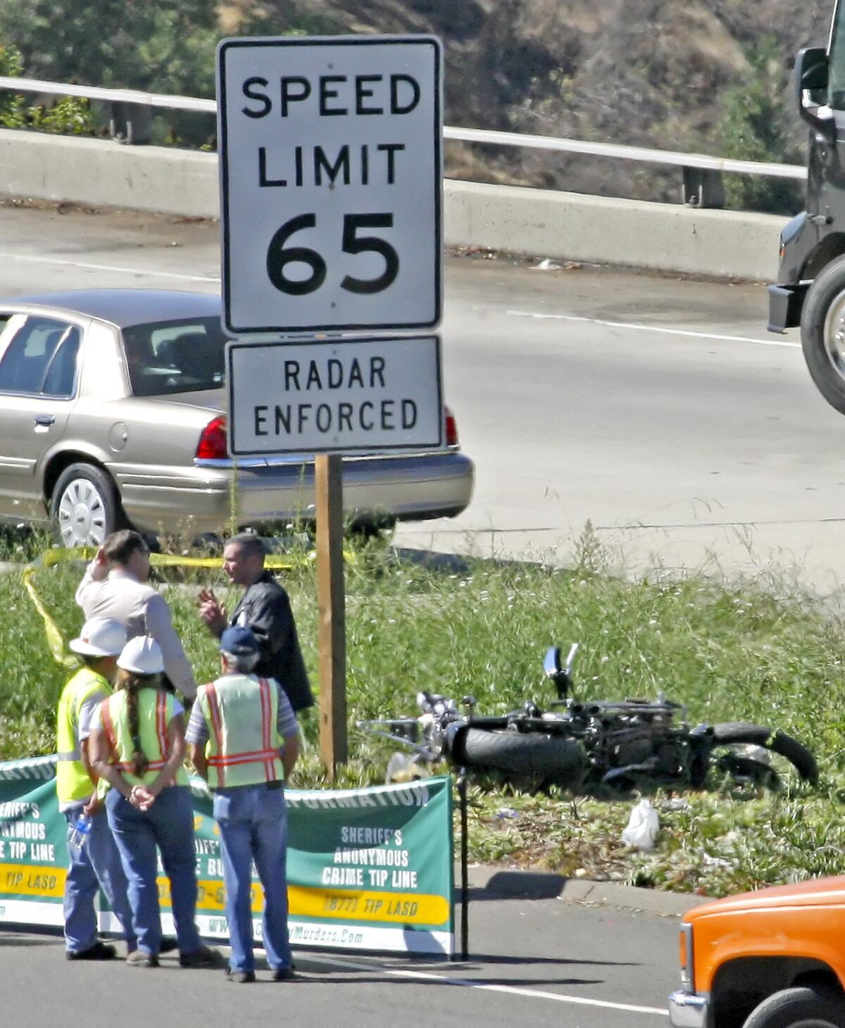 Emergency personnel talk near the wrecked motorcycle of man who was shot and killed early Wednesday morning, October 8, 2008. A reputed gang member accused of killing a Mongols Motorcycle Club member on the Glendale (2) Freeway in 2008 was sentenced on Wednesday, April 16, 2014, to life without the possibility of parole.