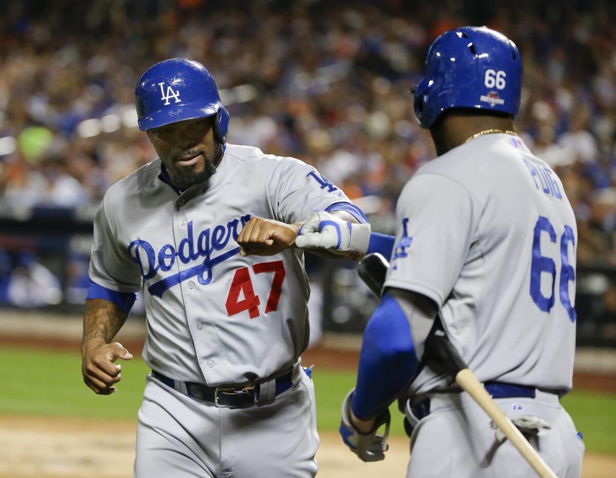 Dodgers second baseman Howie Kendrick is greeted by Yasiel Puig after scoring against the New York Mets during the third inning of Game 4 of the NLDS.