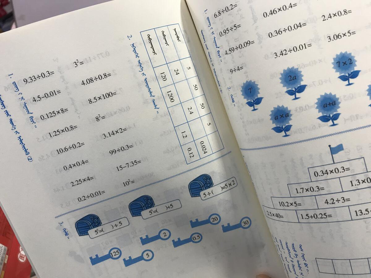 An elementary school math textbook in Mongolian is shown.