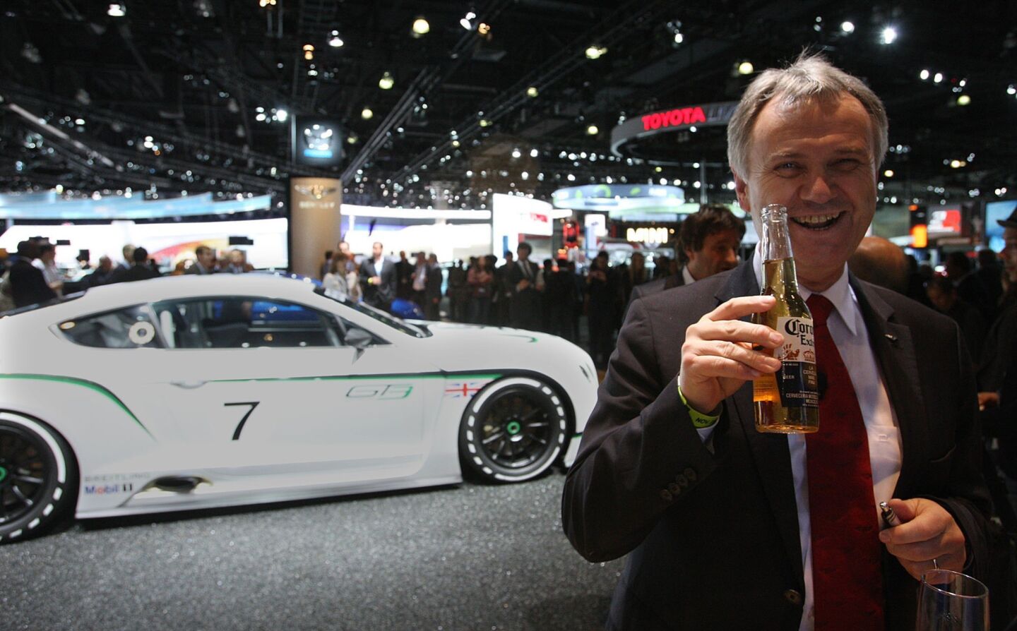 Rolf Frech, a member of Bentley's engineering board, enjoys a beer at the L.A. Auto Show. Behind him is the Bentley Continental GT3 concept race car, making its U.S. debut. It's the luxury car maker's fastest-ever road car.