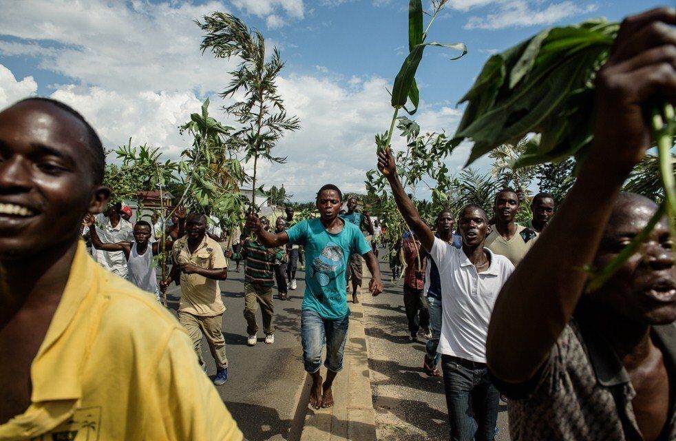 People wave branches to celebrate in the streets of Bujumbura following the radio announcement that President Nkurunziza was overthrown. Nkurunziza says he remains in power.