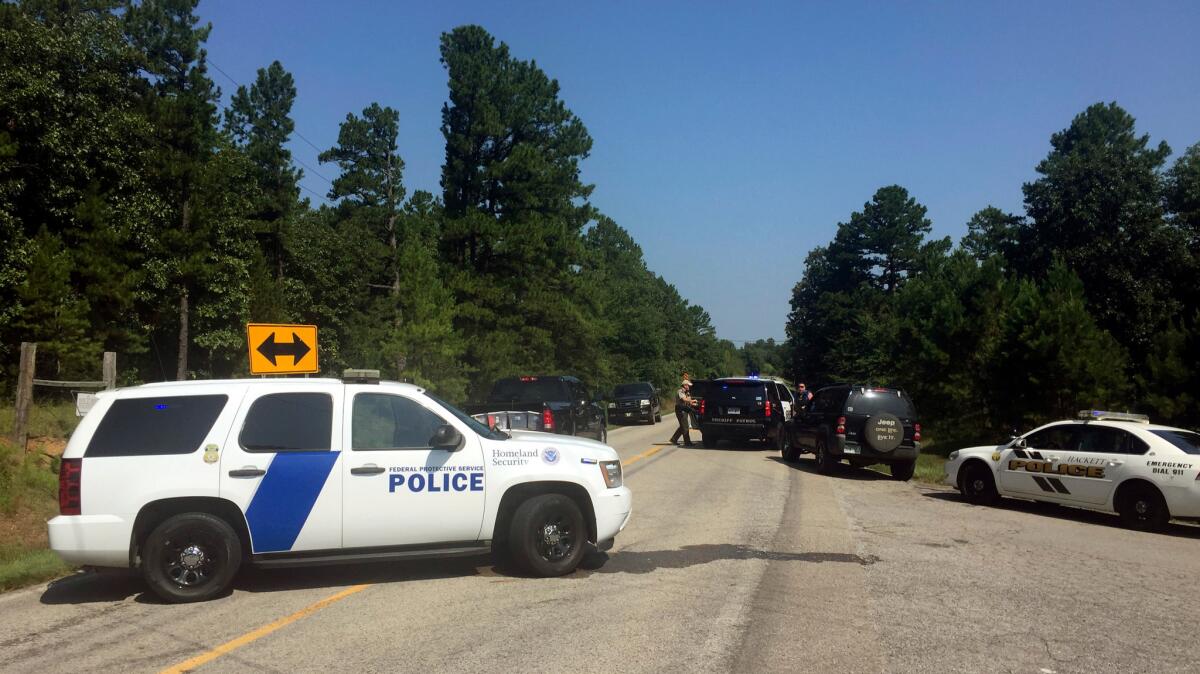 Law enforcement officials block an intersection during a standoff after two officers were shot in western Arkansas on Wednesday.