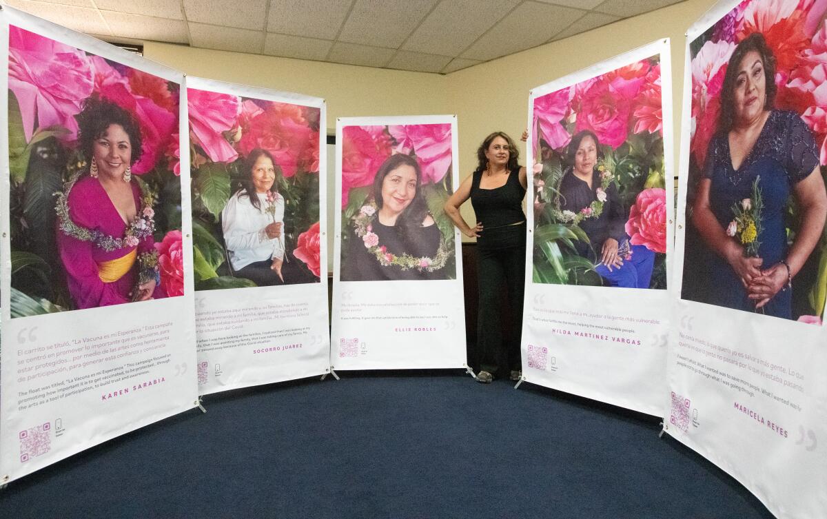 Alicia Rojas poises with banners that highlight "promotoras" from Latino Health Access, a nonprofit group based in Santa Ana.