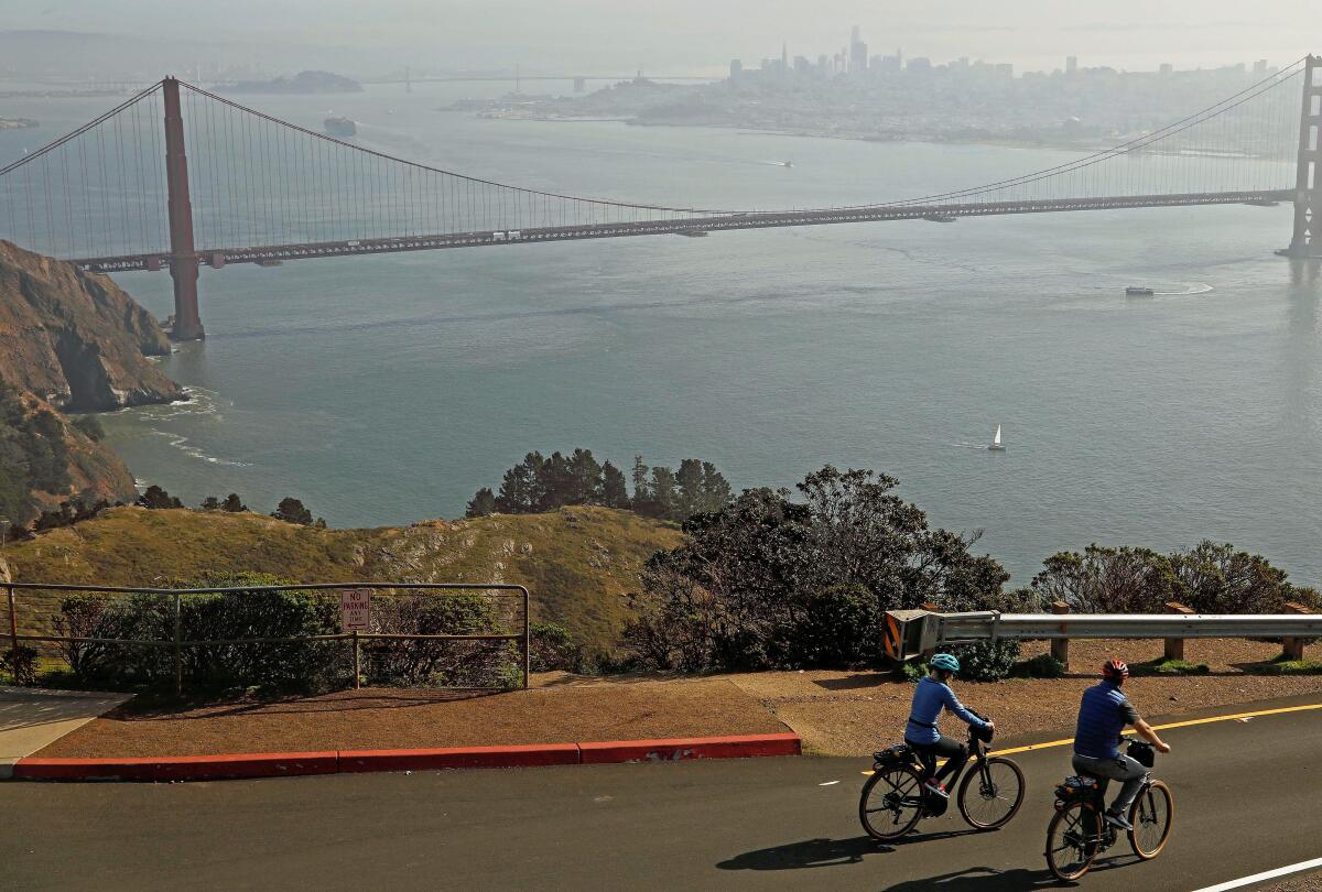 Renata Lima, left, and husband Lucas Lima, from Sao Paulo, Brazil, ride their e-bikes on Hawk Hill in the Marin Headlands.