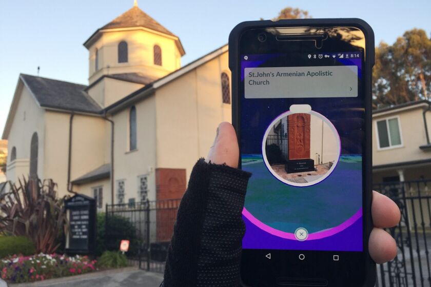 This Wednesday, July 13, 2016, photo, shows "Pokemon Go" on a smartphone in front of a church, in San Francisco. As players of the addictive smartphone game “Pokemon Go” traipse around real-world landmarks in pursuit of digital monsters, some ticked-off property owners are asking to have their positions in the game removed. The list includes the U.S. Holocaust Memorial Museum, Arlington National Cemetery and several ordinary churches and cemeteries. (AP Photo/David Hamilton)