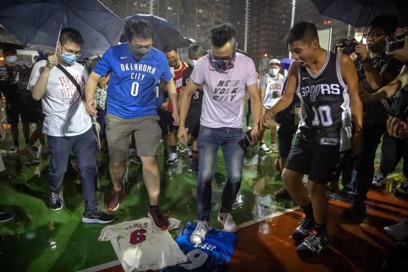 Demonstrators stamp on Lebron James jerseys during a rally at the Southorn Playground in Hong Kong, Tuesday, Oct. 15, 2019. Protesters in Hong Kong have thrown basketballs at a photo of LeBron James and chanted their anger about comments the Los Angeles Lakers star made about free speech during a rally in support of NBA commissioner Adam Silver and Houston Rockets general manager Daryl Morey, whose tweet in support of the Hong Kong protests touched off a firestorm of controversy in China. (AP Photo/Mark Schiefelbein)