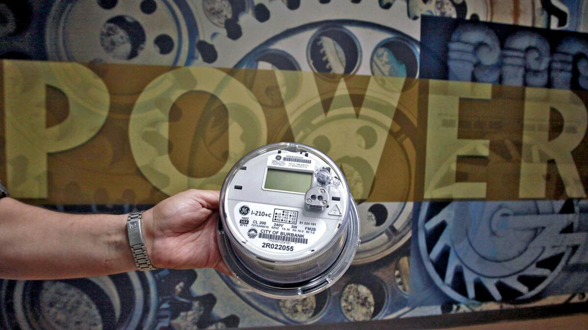Burbank Water & Power spokesman Joe Flores holds a Smart Meter at the utility's building on Magnolia Avenue in Burbank on Wednesday, September 28, 2011.