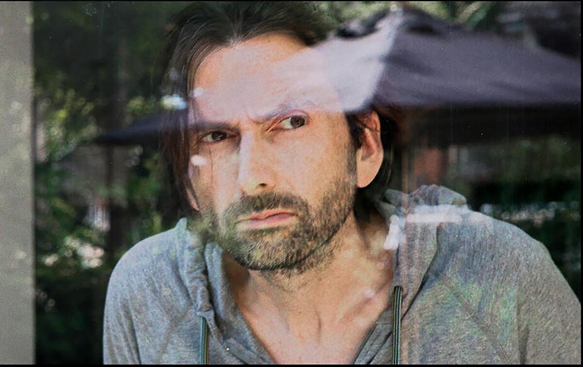 David Tennant looks out a window in "Staged."