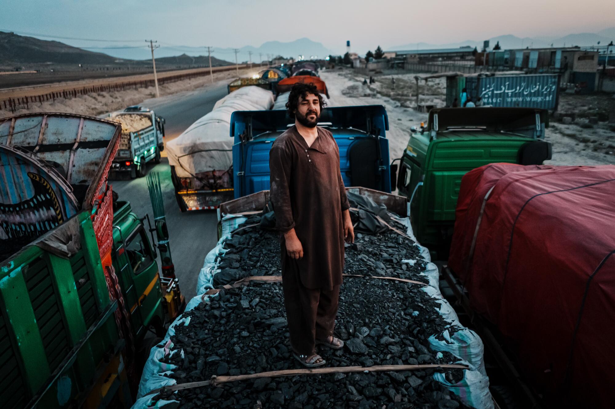 Man standing atop truck laden with coal