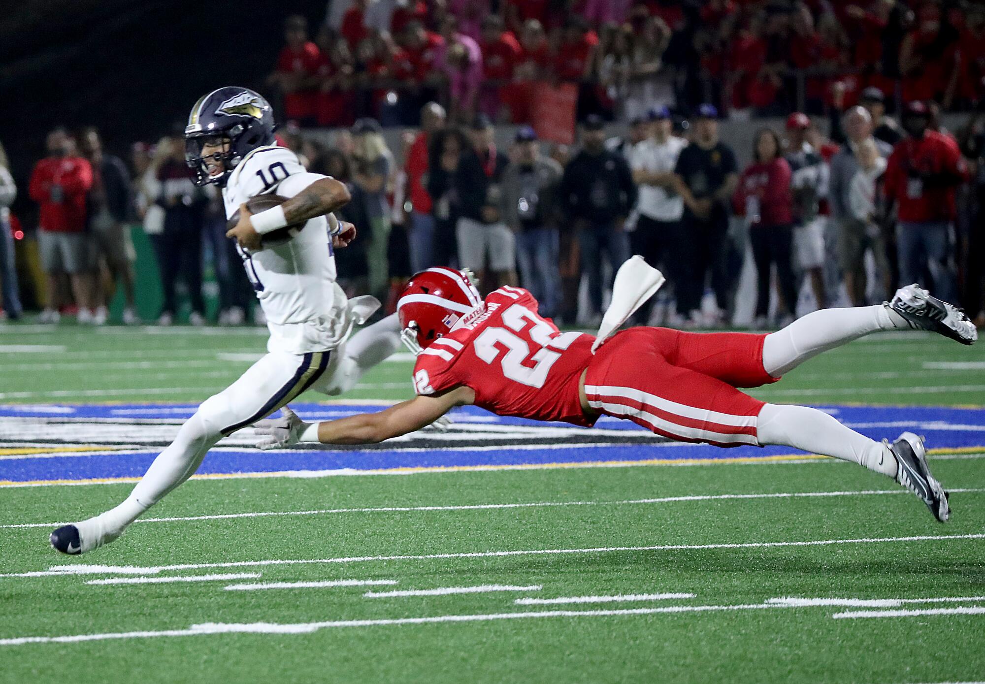 A St. John Bosco ball carrier eludes a leaping Mater Dei tackler 
