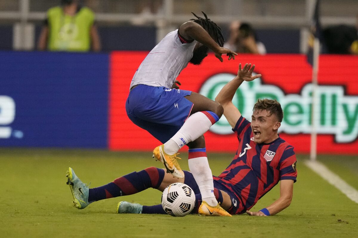 United States defender Sam Vines (3) and Haiti defender Stephane Lambese, left, battle for the ball during the first half of a CONCACAF Gold Cup soccer match Sunday, July 11, 2021, in Kansas City, Kan. (AP Photo/Charlie Riedel)