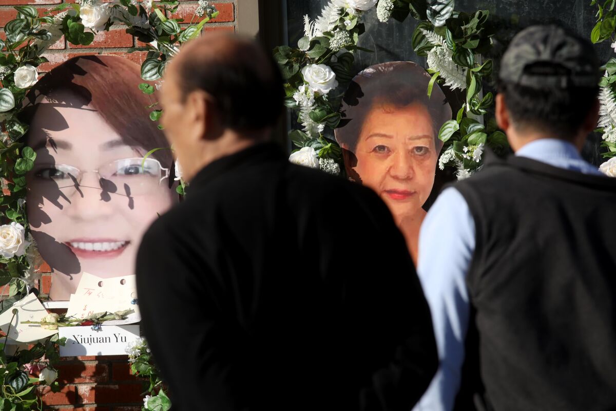 Two men face away, viewing images of the faces of two women, surrounded by white-rose wreaths.