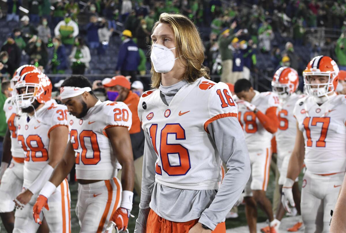 Trevor Lawrence (16) leaves the field with his teammates after Clemson lost to Notre Dame. (Matt Cashore/Pool Photo via AP)