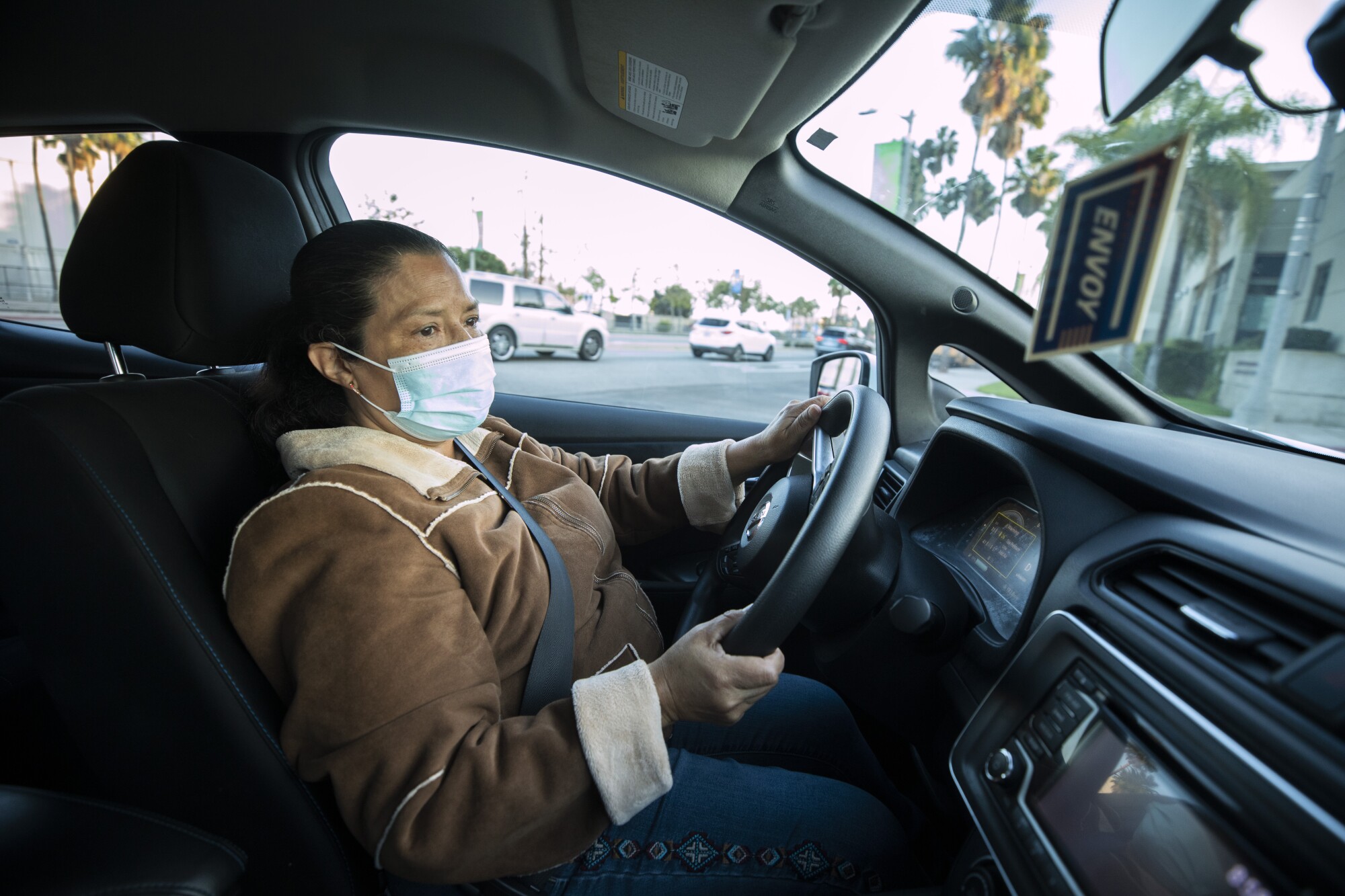 Maria Consuelo Montes sits behind the wheel of an electric car. 