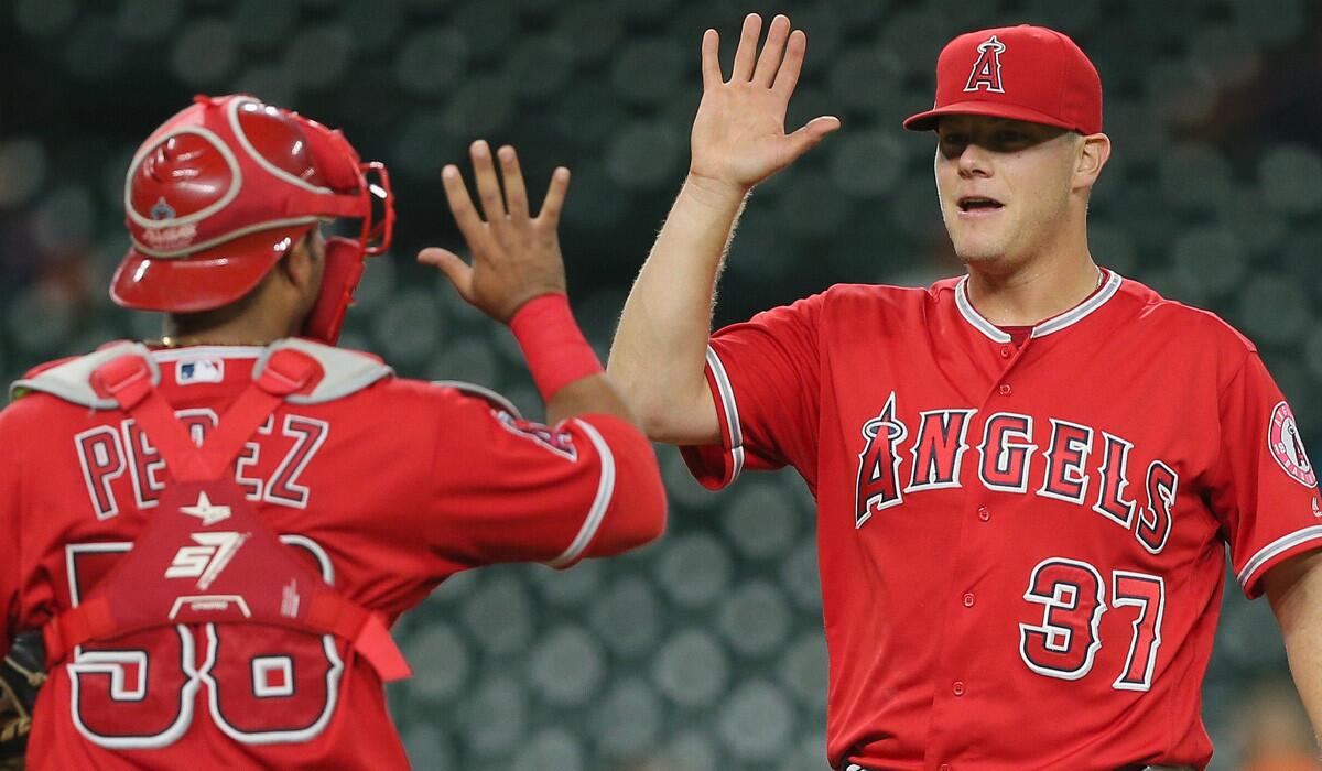 Pitcher Andrew Bailey, enjoying a victory with catcher Carlos Perez in September, re-signs with the Angels.