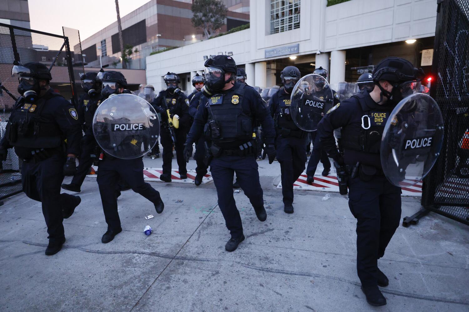 Los Angeles, CA - September 01: DHS Police push out from the back entrance of the Edward R. Roybal Federal Building as demonstrators gather outside the building barricades to advocate for immigrant rights on Labor Day, Monday, Sept. 1, 2025 in Los Angeles, CA. (Carlin Stiehl / Los Angeles Times)