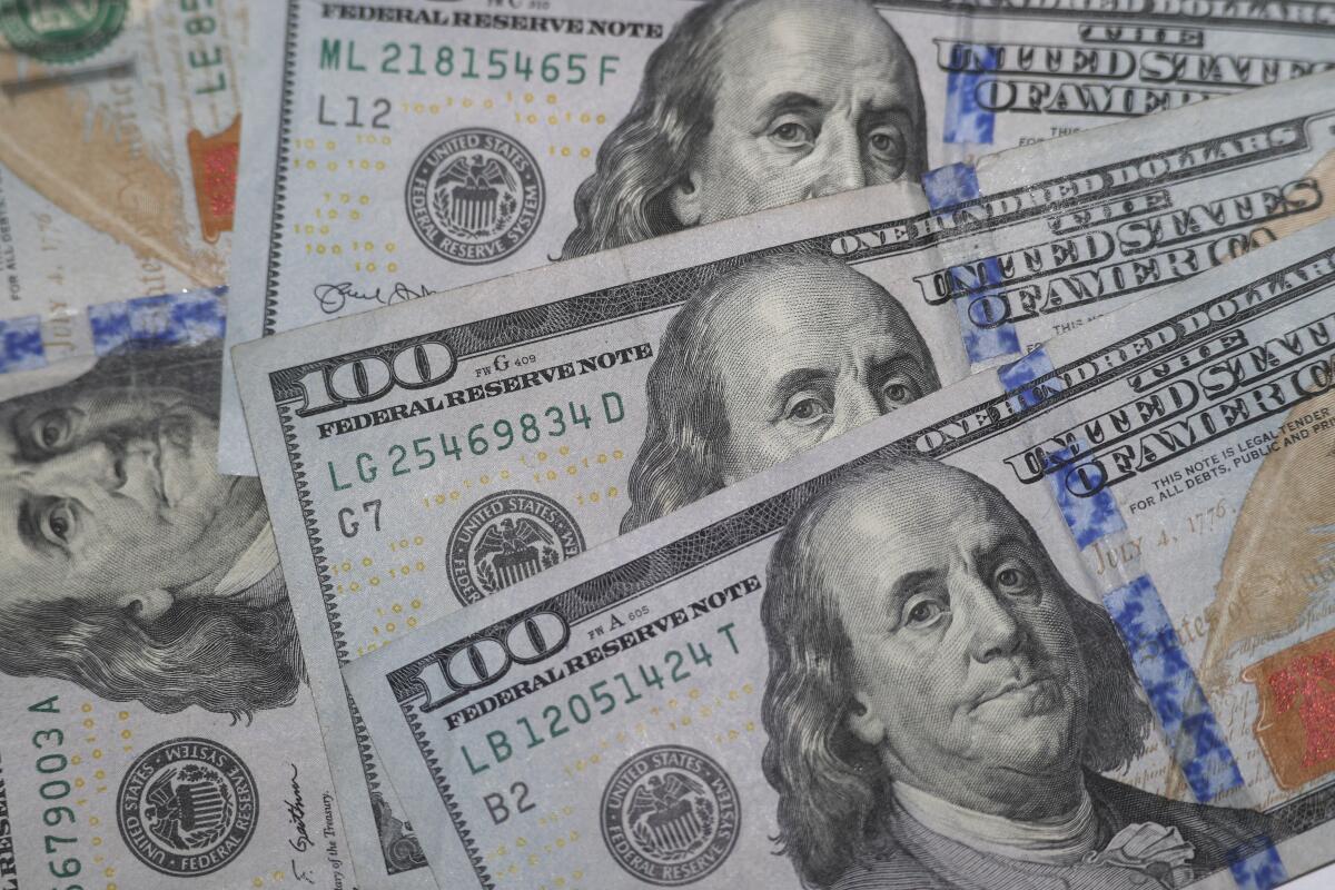 A pile of $100 bills featuring Benjamin Franklin's portrait  