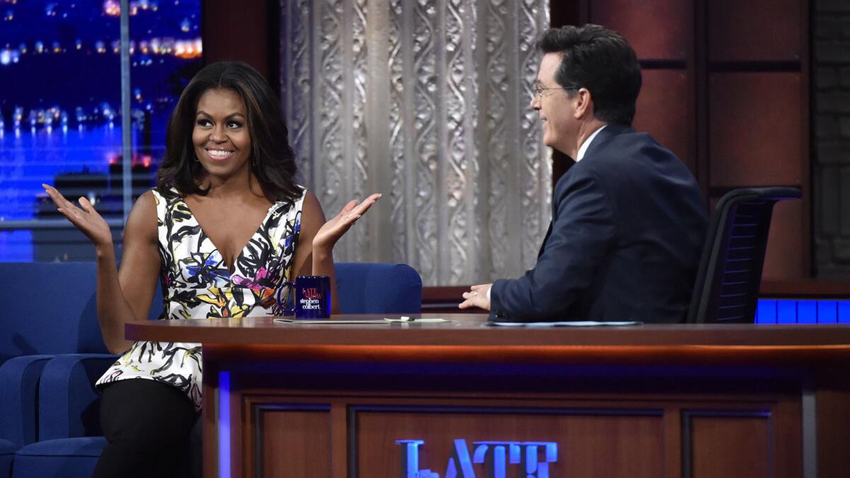 First Lady Michelle Obama, left, appears with host Stephen Colbert during a taping of "The Late Show with Stephen Colbert."