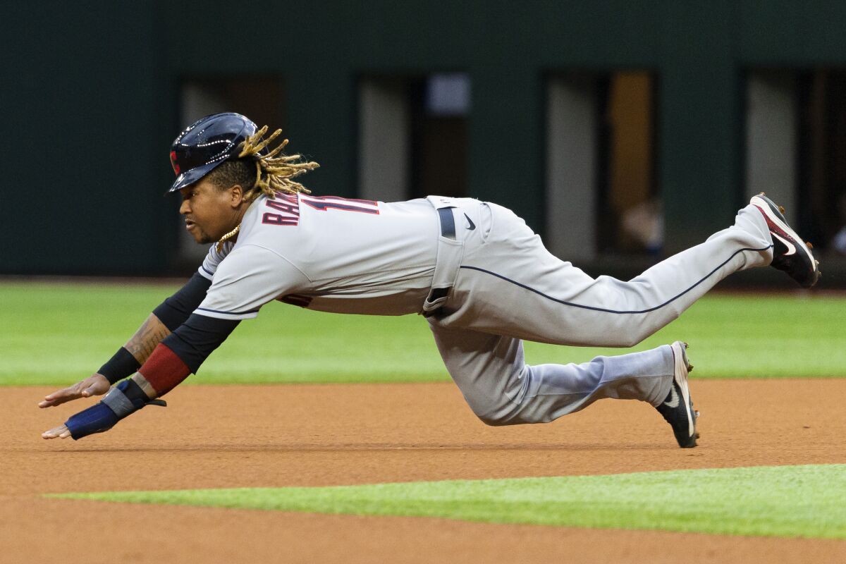 FILE - Cleveland Indians' Jose Ramirez dives toward second base during the first inning of a baseball game against the Texas Rangers, Saturday, Oct. 2, 2021, in Arlington, Texas. The Indians picked up All-Star third baseman José Ramírez's $12 million contract option for 2022 after he had another MVP-caliber season. (AP Photo/Sam Hodde, File)
