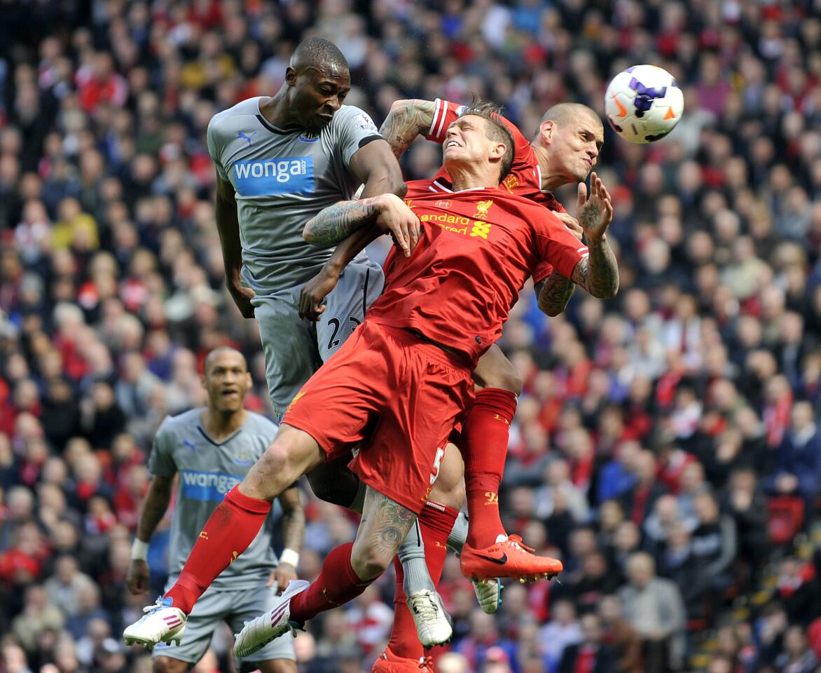 Liverpool's Daniel Agger, center, and Martin Skrtel, right, jump for the ball with Newcastle United's Shola Ameobi during an English Premier League match at Anfield in Liverpool.