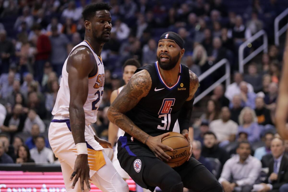 Clippers forward Marcus Morris spins to the basket to try to score against Suns center Deandre Ayton during the first half of a game Feb. 26, 2020, in Phoenix.