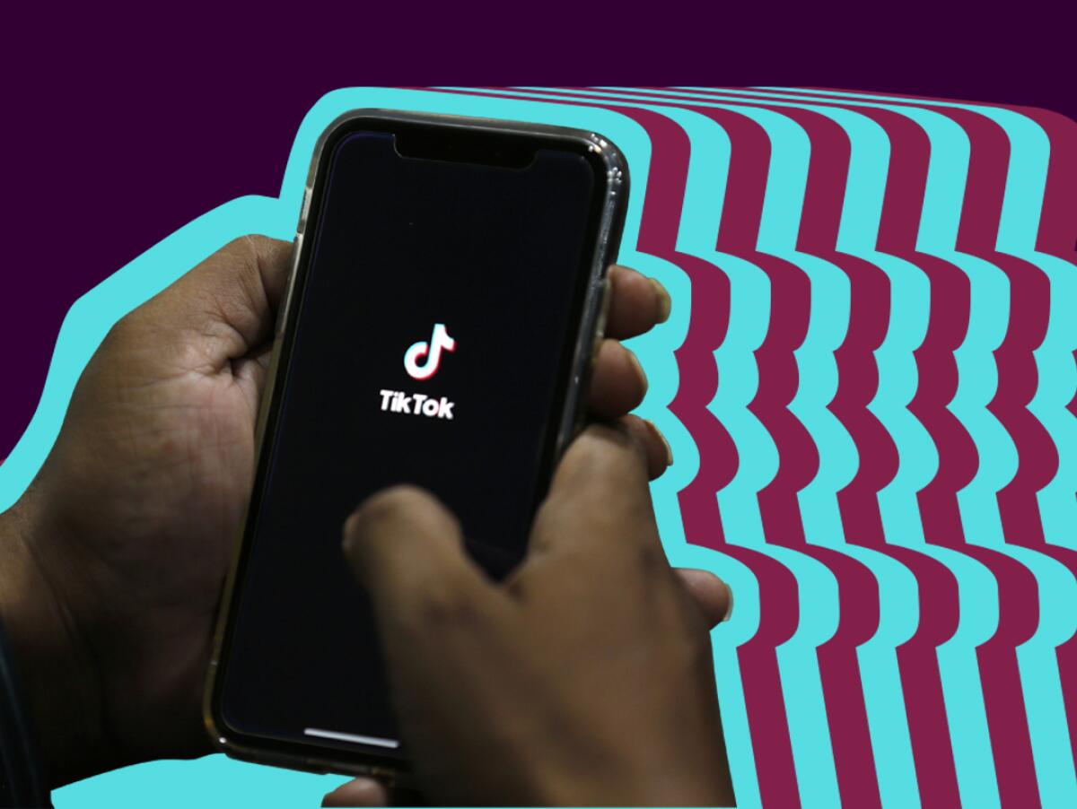 Two hands holding a cellphone with the TikTok logo on screen against a colorful stylized background.