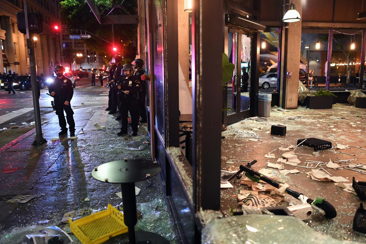Police officers stand outside a damaged business in downtown Los Angeles