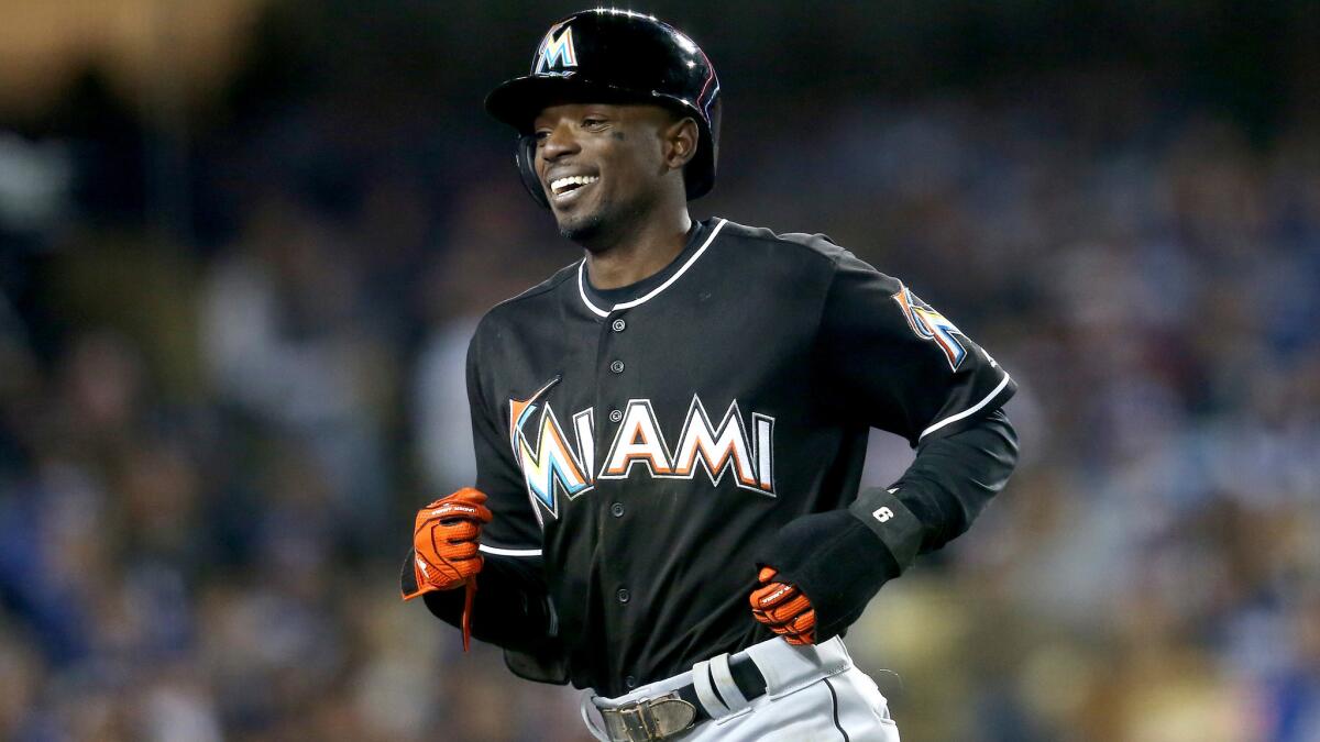 Marlins second baseman Dee Gordon returns to the dugout after scoring a run against the Dodgers on a balk in the seventh inning Thursday night.